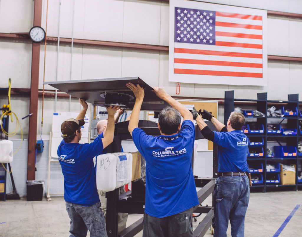 Columbia Tech associates demonstrate their award winning collaboration skills as a team works together to assemble capital equipment.