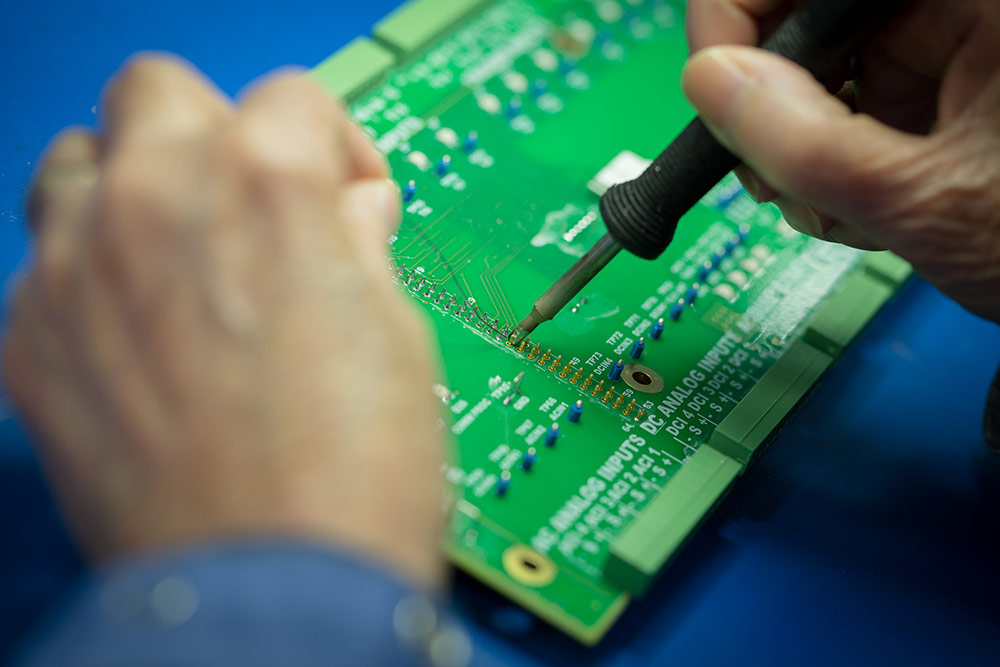 Hand soldering components on a printed circuit board at Columbia Tech