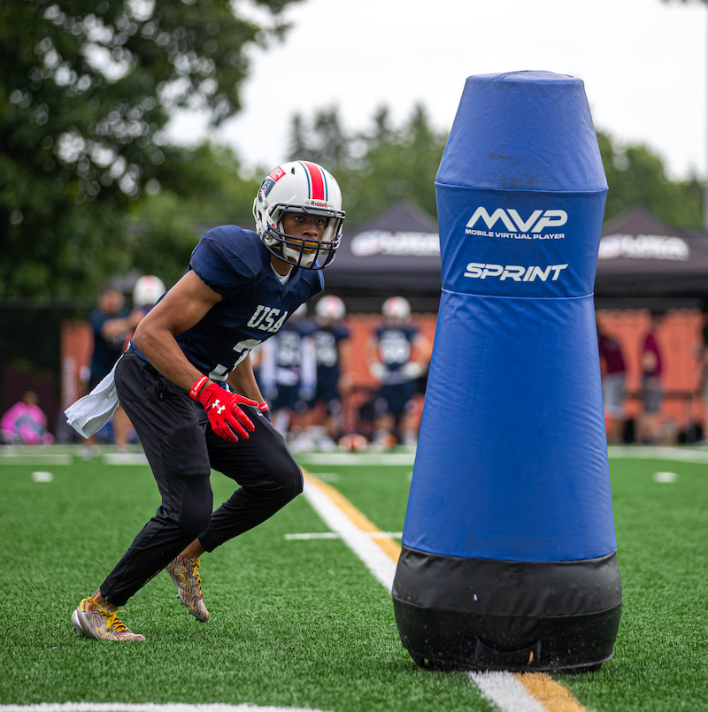 mvp-sprint-football-training-dummy-columbia-tech A football player runs toward a blue MVP Sprint football tackling dummy manufactured at Columbia Tech.