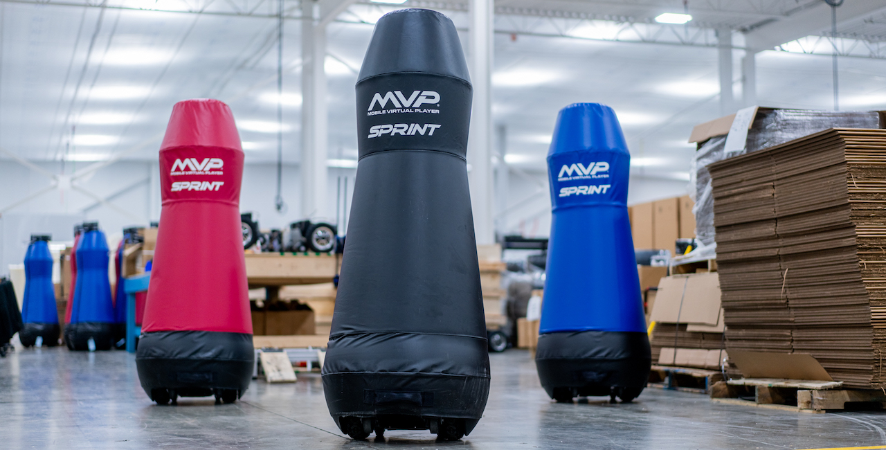 A red, a black, and a blue MVP Sprint tackling dummy standing in the Columbia Tech production facility.